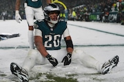 Philadelphia Eagles running back Saquon Barkley (26) sits in the snow as he celebrates his touchdown during the second half of an NFL football NFC divisional playoff game against the Los Angeles Rams on Sunday, Jan. 19, 2025, in Philadelphia.